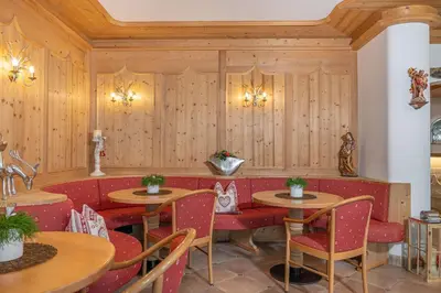 a restaurant with wooden walls and tables and chairs at Hotel Rodella in Selva di Val Gardena