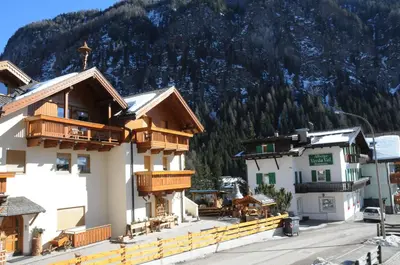 a group of buildings in front of a mountain at Verda Val in Campitello di Fassa