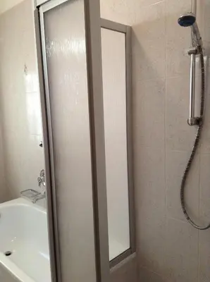 a shower with a glass door in a bathroom at Verda Val in Campitello di Fassa