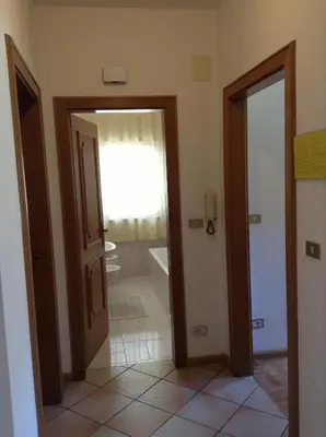a hallway with two doors and a bathroom at Verda Val in Campitello di Fassa