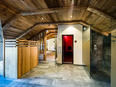 a hallway with wooden ceilings and a red door at Hotel Vernel in Santa Cristina in Val Gardena