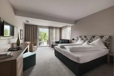 a hotel room with a large bed and a desk at Boutiquehotel Minigolf in Tirolo