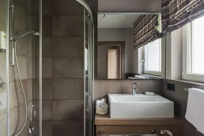 a bathroom with a sink and a shower at Boutiquehotel Minigolf in Tirolo