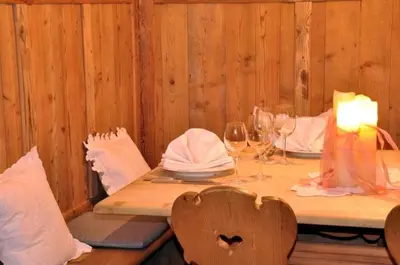 a wooden table with a candle and wine glasses at Hotel Ansitz Kandelburg in Mühlbach