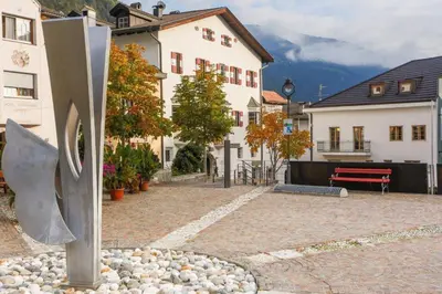a sculpture in the middle of a courtyard with a building at Hotel Ansitz Kandelburg in Mühlbach