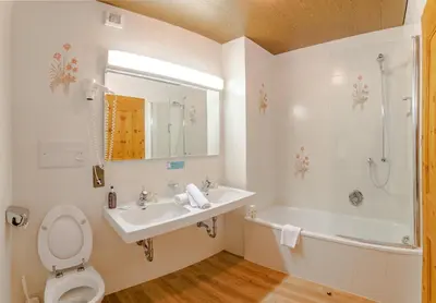 a bathroom with a sink and a shower at Hotel Alaska in Selva di Val Gardena