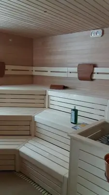 a sauna with white cabinets and a sink at Hotel Garnì Gardena - Appartments in Santa Cristina in Val Gardena