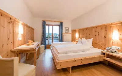 a bedroom with a bed and two desks and a window at Hotel Jonathan in Naz-Sciaves