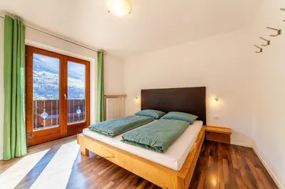 a bedroom with a large bed with red pillows at Bognerhof in Rifiano