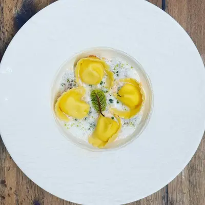 a bowl of food on a white plate at Hotel Reipertingerhof in Brunico