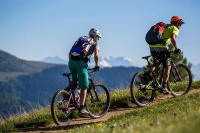 two people riding bikes on a mountain trail at Hotel Reipertingerhof in Brunico