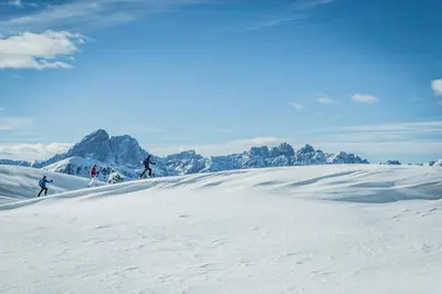 a group of people skiing down a snow covered slope at Hotel Reipertingerhof in Brunico