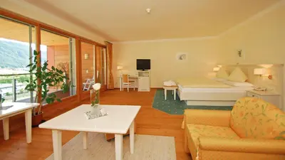 a living room with a bed and a couch at Hotel Olympia in Brunico