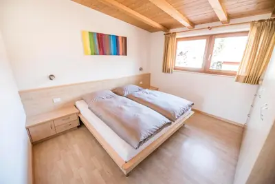 a bedroom with a bed in a room with a window at WEINBERG APARTMENTS with Brixen Südtirol Card in Naz-Sciaves
