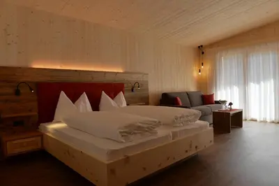 a bedroom with two beds and a couch at Naturhotel Haller in Racines