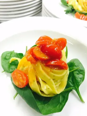 a plate of food with tomatoes on top at Naturhotel Haller in Racines