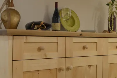 a wooden cabinet with a counter top with wine bottles at Naturhotel Haller in Racines