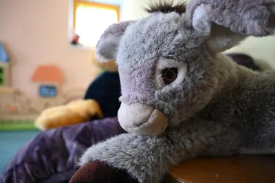 a stuffed rabbit is sitting on a bed at Naturhotel Haller in Racines