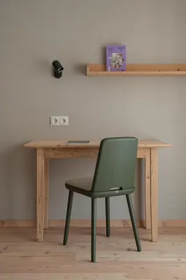 a green chair sitting at a wooden desk at Vitalpina Hotel Schulerhof in Plaus