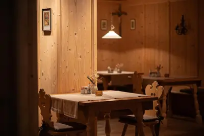 a dining room with a table with chairs and a sink at Vitalpina Hotel Schulerhof in Plaus