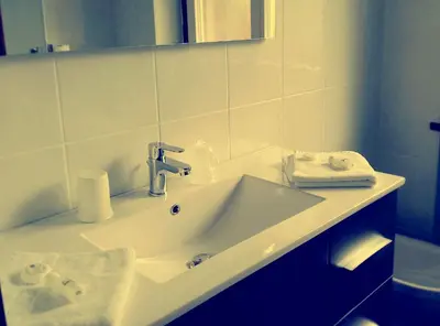 a white bathroom with a sink and a mirror at Hotel Bologna in Brunico