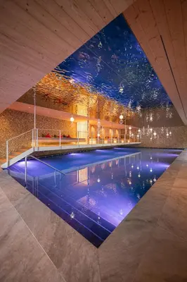 a swimming pool in a building with a ceiling at Hotel Anewandter in Brunico