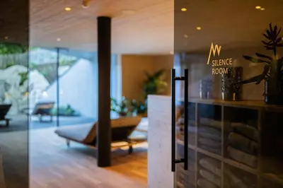 two views of a living room and a lobby at Hotel Anewandter in Brunico