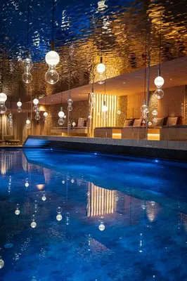 a swimming pool in a hotel with lights on it at Hotel Anewandter in Brunico