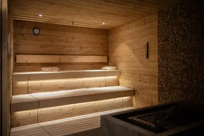 a sauna with wooden walls and stairs in a room at Hotel Anewandter in Brunico