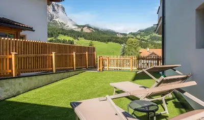 a balcony with a patio furniture and a view of a mountain at Hotel Cavallino in Badia