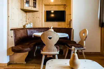 a living room with a couch and chairs and a tv at Garni Hotel and Apartments Wildbach in Selva di Val Gardena