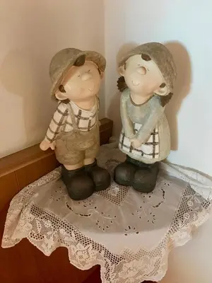 two figurines of two people sitting on a table at Garni Hotel and Apartments Wildbach in Selva di Val Gardena