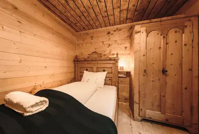 a bedroom of a log cabin with a bed in it at Hirschhof Pfrein - Hideaway in Chiusa