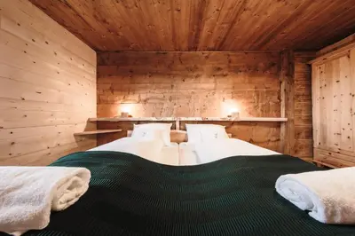 a bedroom with two beds in a wooden cabin at Hirschhof Pfrein - Hideaway in Chiusa