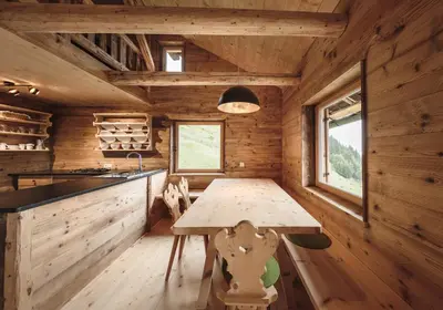 a kitchen in a log cabin with a wooden table at Hirschhof Pfrein - Hideaway in Chiusa