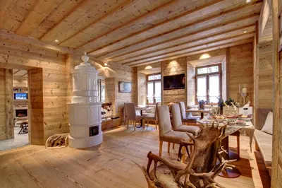 a dining room with a table and a stove at Hotel Villa Alpina ***S in Cortina dʼAmpezzo