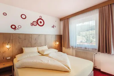 a bedroom with a white bed and a window at Pension Wiesenrain in Maranza