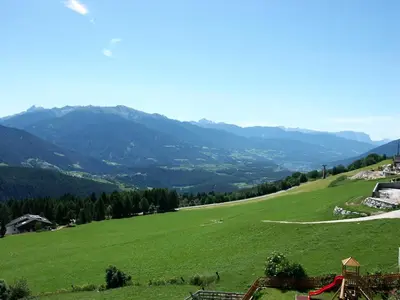 a green field with mountains in the background at Pension Wiesenrain in Maranza