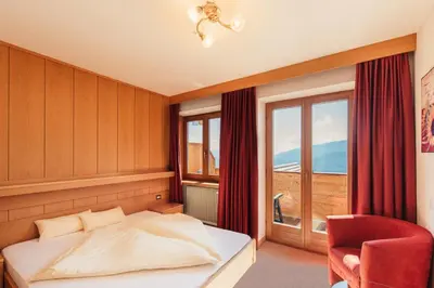 a bedroom with a bed and a large window at Pension Wiesenrain in Maranza
