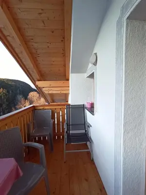 a balcony of a house with chairs and a table at Haus Bergfrieden in Castelrotto