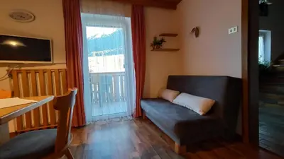 a living room with a couch and a window at Haus Bergfrieden in Castelrotto