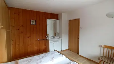 a bedroom with a bed and a sink at Haus Bergfrieden in Castelrotto
