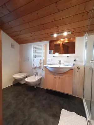 a bathroom with two sinks and two toilets at Haus Bergfrieden in Castelrotto