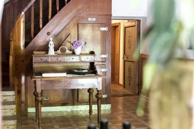 a wooden table in a room with a staircase at Agriturismo Sittnerhof in Merano