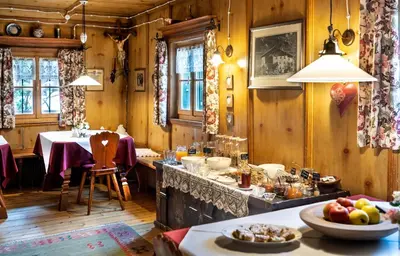 a dining room with a table and a counter with food at Agriturismo Sittnerhof in Merano