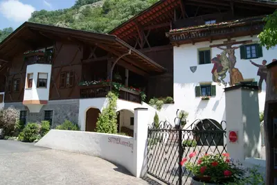 a building with a fence in front of it at Agriturismo Sittnerhof in Merano