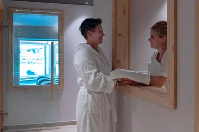 a man and woman standing in front of a mirror at Hotel El Paster in Pozza di Fassa