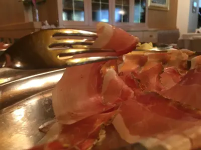 a fork and a slice of pizza on a table at Hotel El Paster in Pozza di Fassa