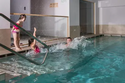 a group of children playing in a swimming pool at Hotel El Paster in Pozza di Fassa