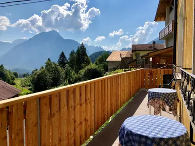 a balcony with two tables and a view of mountains at Stella Alpina in Voltago